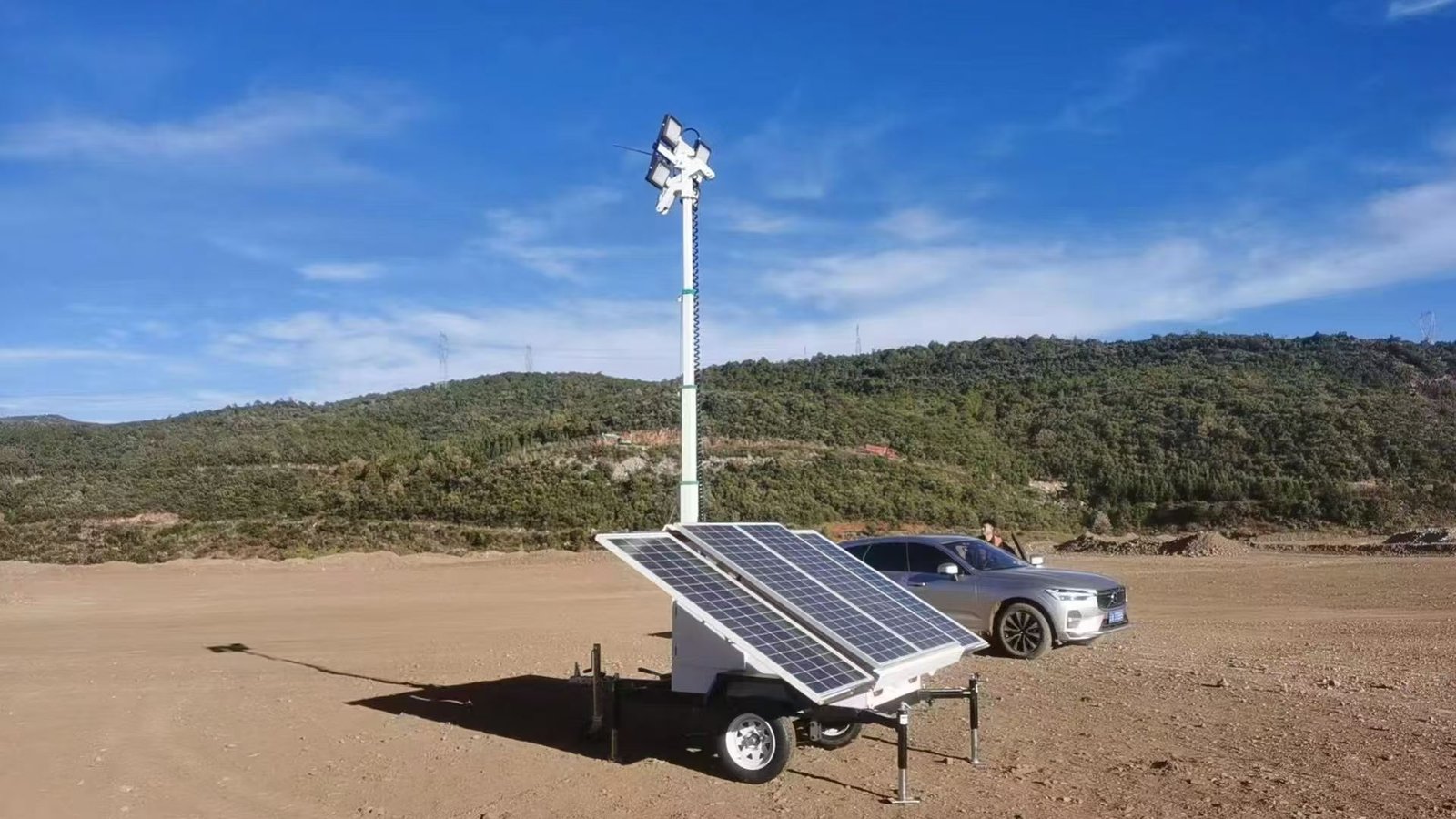 Side view of a solar light tower trailer showing deployed solar panels and stabilizers